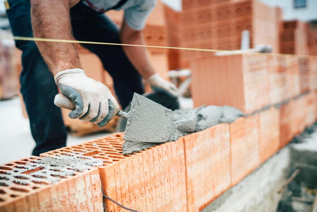 Maurer bei der Arbeit an einer Ziegelwand
